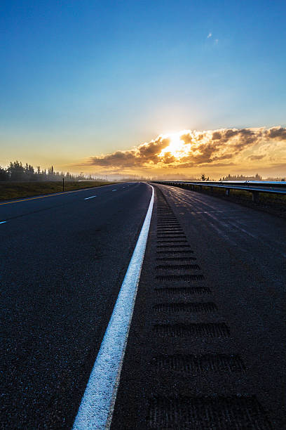 trans-canada highway lever du soleil - asphalt two lane highway natural phenomenon fog photos et images de collection