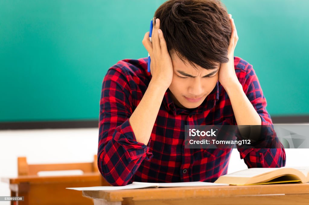 Stressed student  studying for exam in classroom Teenager Stock Photo