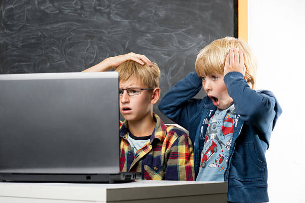 Boys with computer Amazed schoolboys with the notebook blackboard child shock screaming stock pictures, royalty-free photos & images