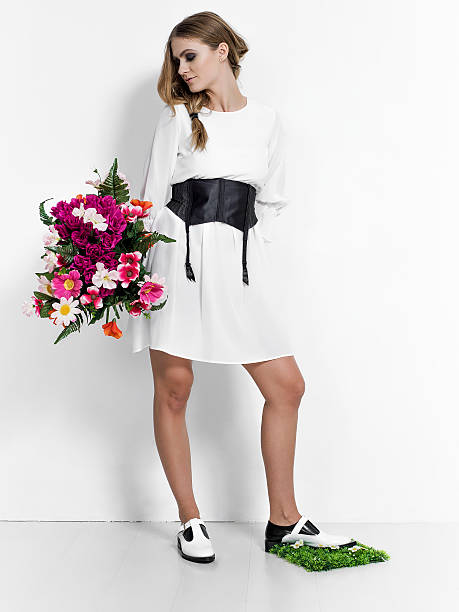 istock Woman holding flowers bunch and stepping on grass clump 510856476
