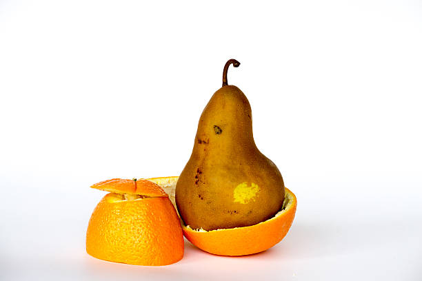 Pear inside an orange GMO are living organisms whose genetic material has been altered to enhance some qualities over others genetic modification change improvement science stock pictures, royalty-free photos & images