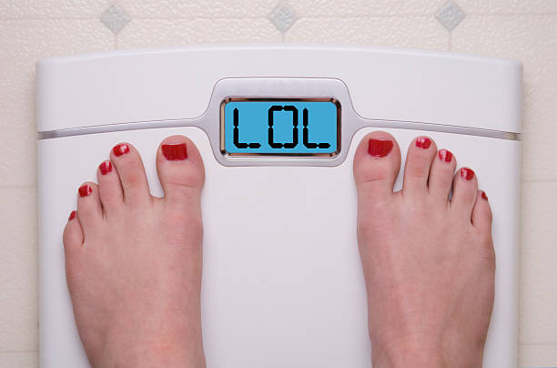 шкале, поставив ноги lol - emaciated weight scale dieting overweight стоковые фото и изображения