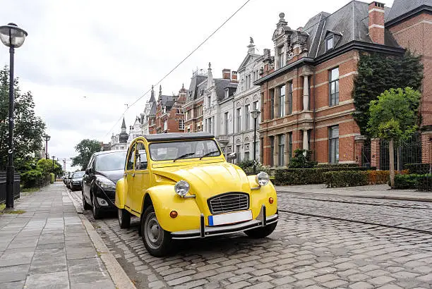 Old, vintage yellow car on european steet, Antwerp, Belgium