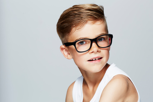 Portrait of young boy wearing glasses, studio