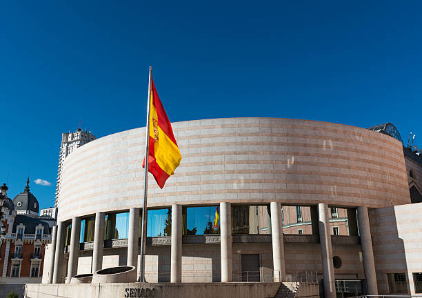 Senate building and Spanish flag in Madrid Side view of the Senate (Senado) building in Madrid, spain, next to Plaza de España. senate stock pictures, royalty-free photos & images