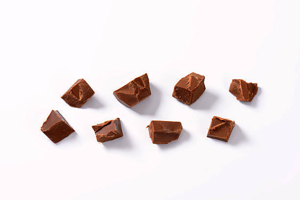 pieces of chocolate pieces of chocolate on white background milk chocolate stock pictures, royalty-free photos & images