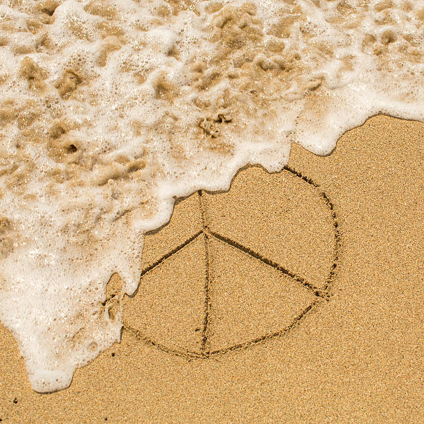 istock Peace sign (pacific) drawn on the sand of a beach 510870922