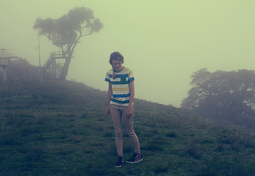 girl in foggy meadow near swing at the Casa del Arbol in Banos, Ecuador