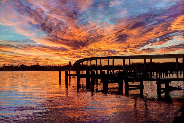 A beautiful orange sunset reflecting on the Severn River.  Pearl Harbor Memorial Bridge in the background.