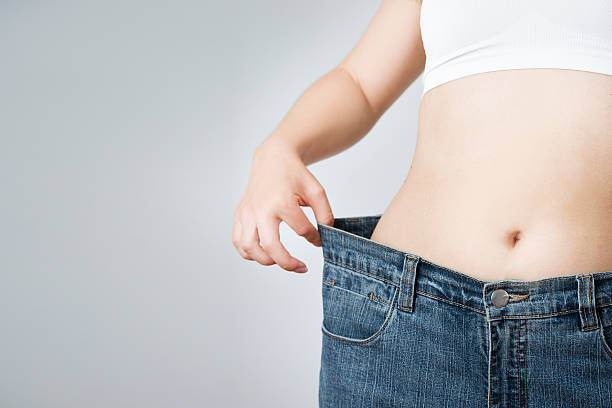 mulher em jeans de tamanho grande, conceito de perda de peso - slenderize imagens e fotografias de stock