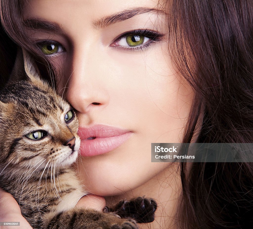 cat eyes beautiful young woman portrait holding kitten, close up Adult Stock Photo