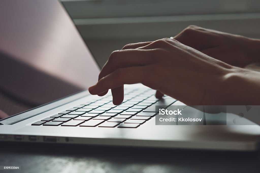woman's hands working on laptop computer Woman working with laptop placed on the black desk Adult Stock Photo
