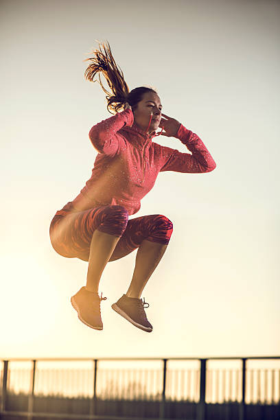 istock Athletic woman jumping high up at sunset. 510927648