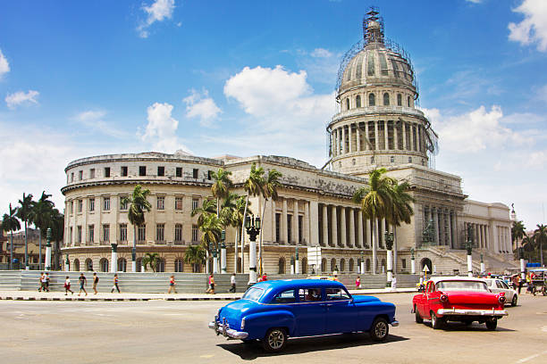 Vintage cars in the city of Havana, Cuba Vintage cars drive past Capitolio, Havana, Cuba capitolio stock pictures, royalty-free photos & images