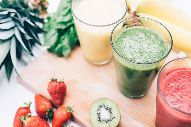 Fruity deliciousness Three fresh, colorful smoothies with some fresh fruit on the table. strawberry crush stock pictures, royalty-free photos & images