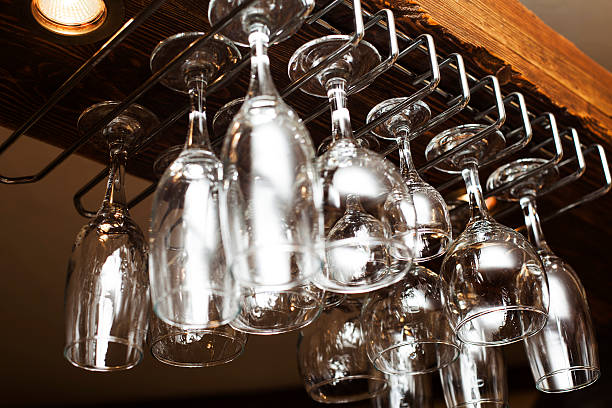 glasses suspended from above the bar stock photo