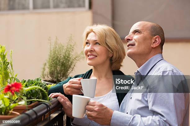 Aged Couple Drink Tea On Balcony Stock Photo - Download Image Now - 50-54 Years, 60-64 Years, Adult