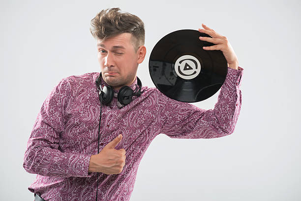 istock DJ posing with vinyl record and thumb up 510950093