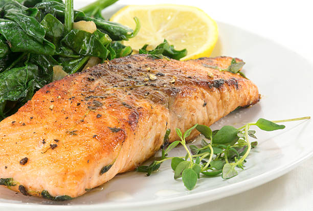 istock grilled salmon with thyme, lemon and spinach, white plate 510950412