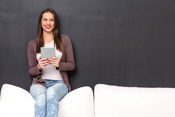 istock Girl sitting on a couch with a tablet 510950520