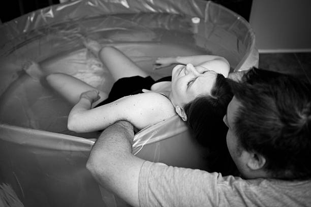 Husband Supporting Wife During Home Water Birth