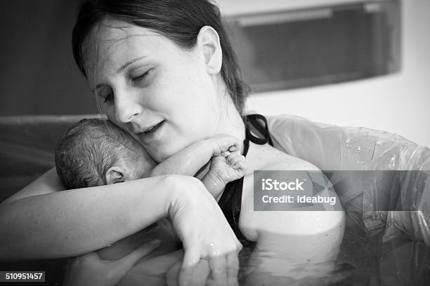 Mother Embracing Her Newborn After Home Water Birth Stock Photo - Download Image Now