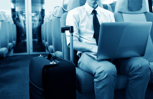Asian businessman on train with laptop computer.