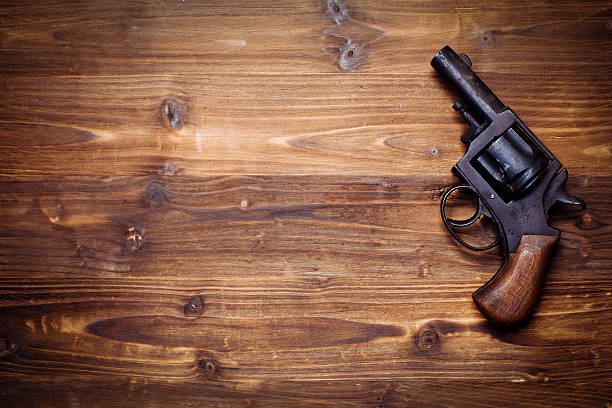 istock Old gun on wooden background 510954284