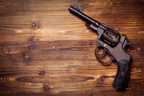 istock Old gun on wooden background 510954576