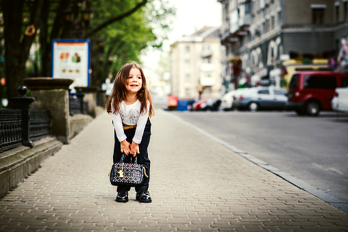 Pretty little girl walking on the city street