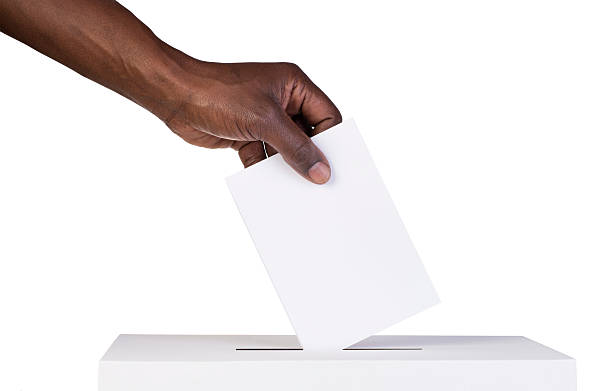 Ballot box with person casting vote Ballot box with person casting vote on blank voting slip polling place photos stock pictures, royalty-free photos & images
