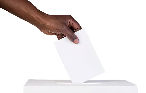 Ballot box with person casting vote on blank voting slip