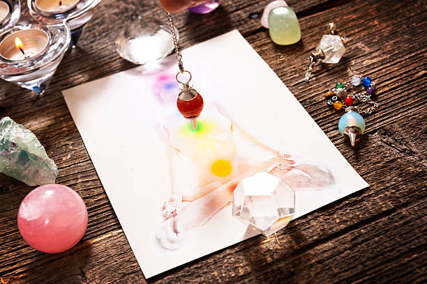 Chakras over a human body Chakras illustrated over human body with natural crystals and pendulum chakra recovery energy gem stock pictures, royalty-free photos & images