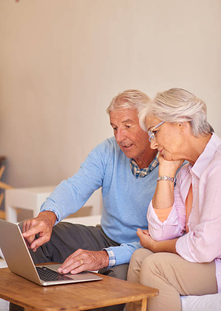 istock Senior couple using laptop together at home 510959820