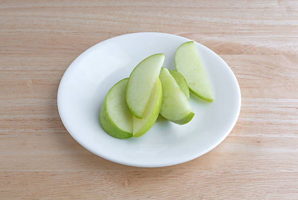 istock Green apple slices on a plate table top 510959954