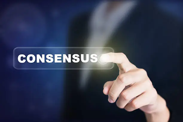 Photo of Businessman pressing a CONSENSUS concept button.