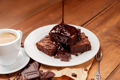 Plate with delicious chocolate brownies on dark vintage wood background.