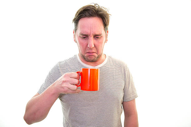 Man does not like his coffee/tea Man does not like his coffee/tea, rudeness, disgust, drinking sour face stock pictures, royalty-free photos & images