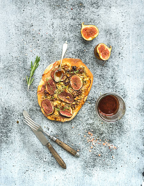Rustic homemade pizza with figs, prosciutto and mozzarella cheese over
