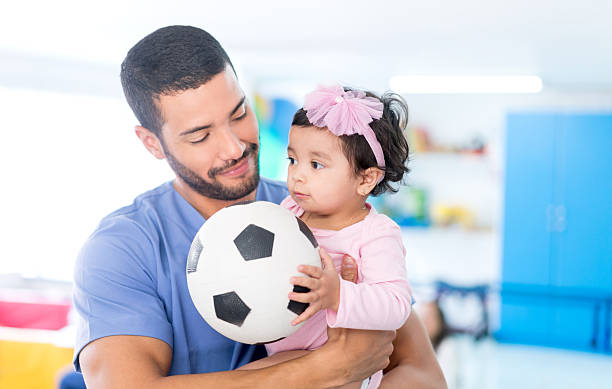 infirmière jouant au football avec une petite fille - patient male nurse nurse hospital photos et images de collection