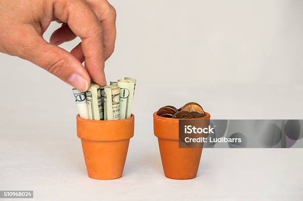 Money Being Put In A Terracotta Pot Stock Photo - Download Image Now - 2000-2009, American Fifty Dollar Bill, American One Dollar Bill