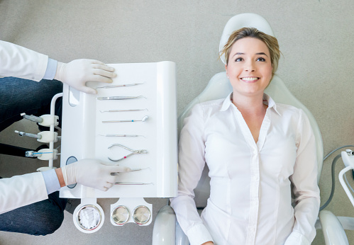 Nervous woman at the dentist lying on the chair - oral health concepts