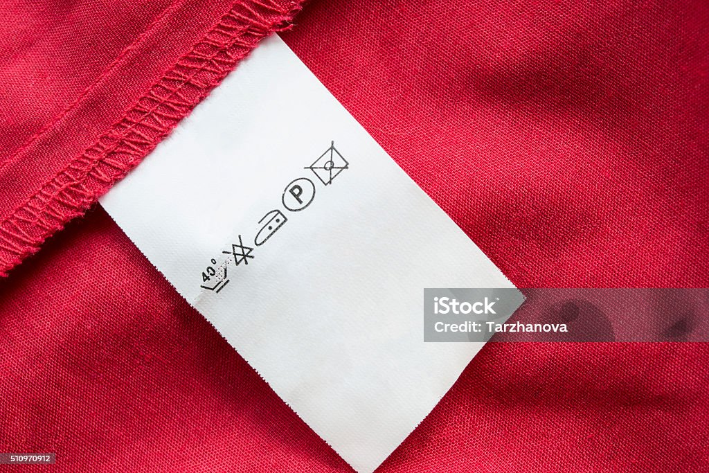 Washing instructions label Red cotton with white washing instructions label Abstract Stock Photo