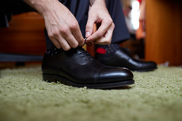 istock Man's hands gging black dress shoes 510971018