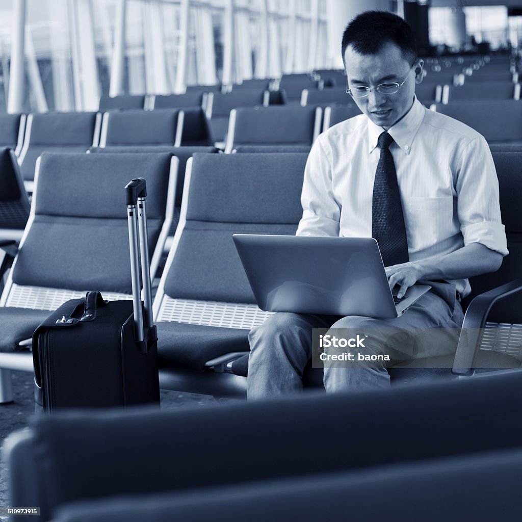 waiting traveller using mobile phone Young businessman working on his laptop in the airport. 30-34 Years Stock Photo