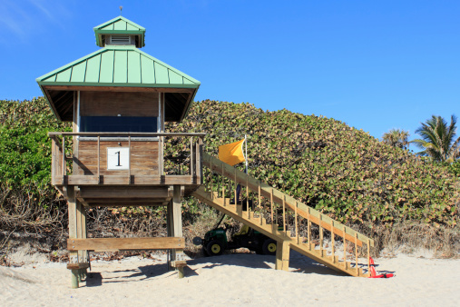 Boca Raton, FL, USA - February 1, 2013: A lifeguard tower displays a yellow flag warning people to exercise caution and stay near lifeguard station.