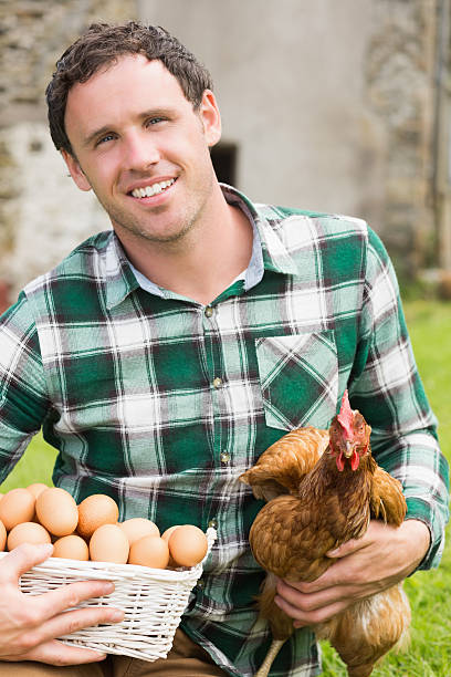 istock Young man holding his chicken and basket of eggs 510975549