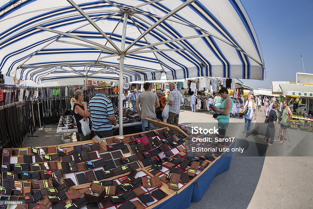 Leathergoods at Caorle´s Market Day Caorle, Italy - June 07, 2014. People try to choose the right items at the dealer in  leathergoods. Awning Stock Photo