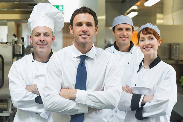 istock Young restaurant manager posing in front of team 510994573