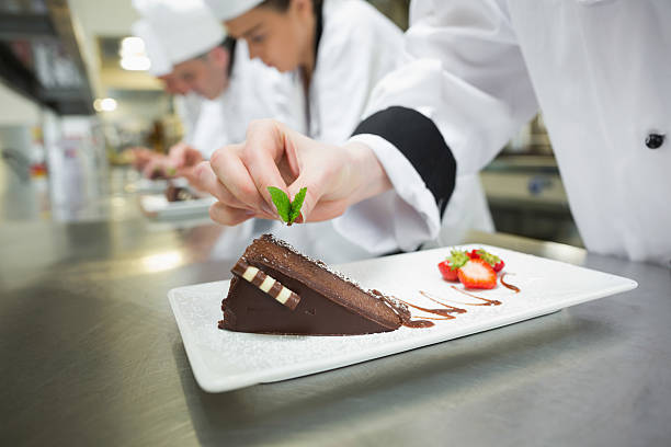 istock Close up of chef putting mint leaf on chocolate cake 510994593